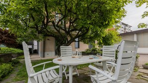 A white outdoor dining set with chairs and a table, surrounded by greenery and a tree. - Villetta con Giardino Allo Stadio by Wonderful Italy (Turin)