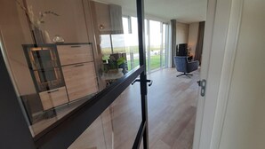 Uma cozinha moderna com armários de madeira, uma porta de vidro e vista para o exterior.