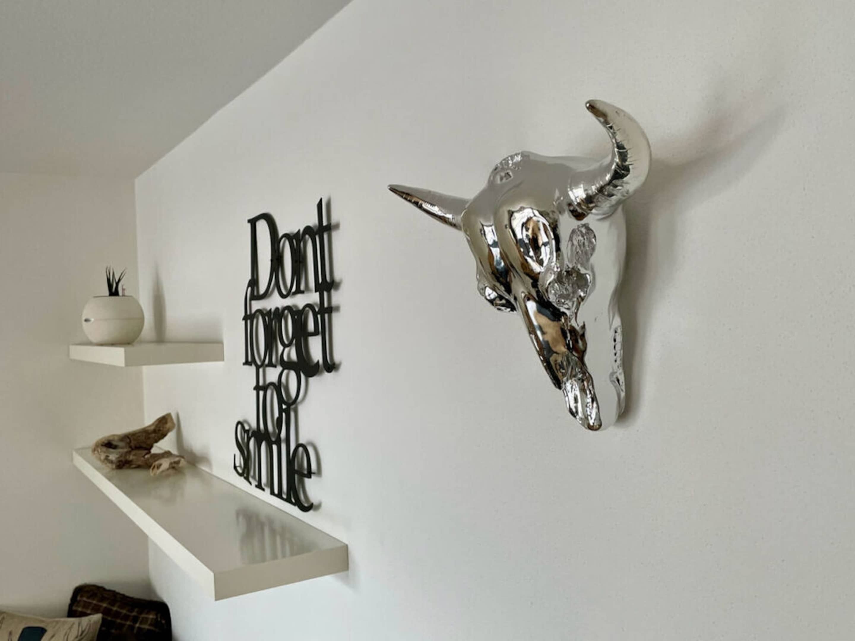A wall with a decorative skull and a motivational quote.