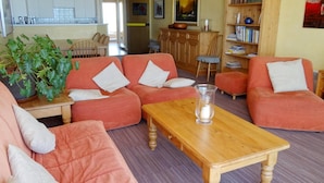 Ein gemütliches Wohnzimmer mit einer Sofagarnitur, einem Holztisch und einem Bücherregal.