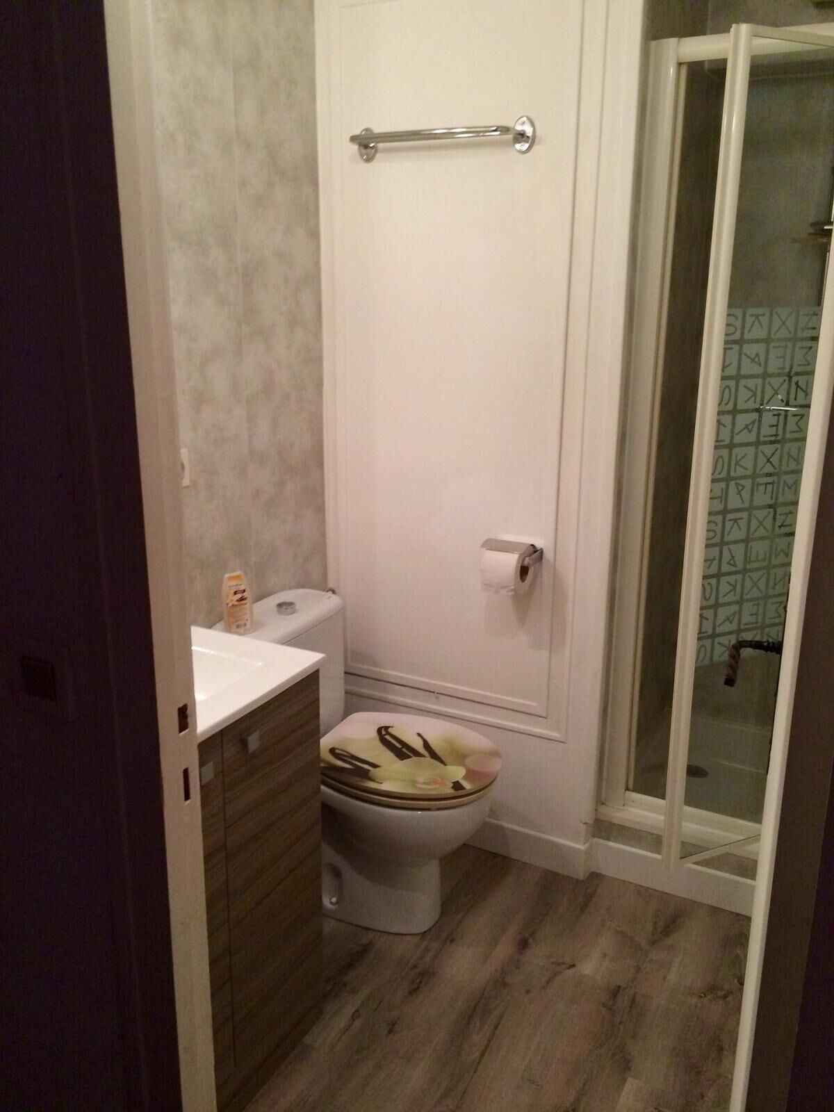 Un baño con inodoro, lavamanos y zona de ducha.