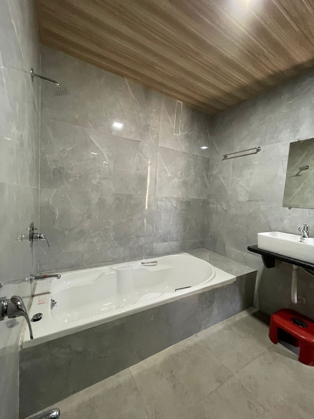 A modern bathroom with a freestanding bathtub, a sink, and a mirror on the wall.