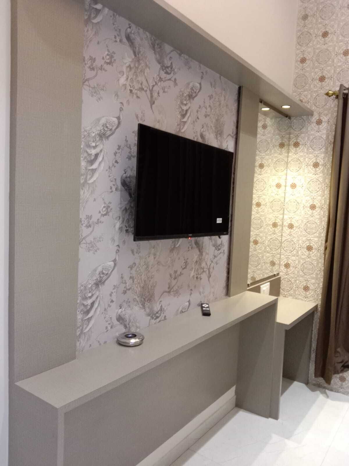 Ein modernes Badezimmer mit Waschtisch, einem angebrachten Fernseher und strukturierten Tapeten.