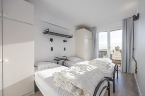 Ett modernt hotellrum med en stor säng, ett skrivbord och utsikt över staden.