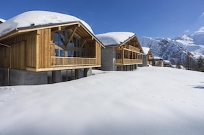 A wooden chalet with a balcony, set against a snowy mountain backdrop. - Wifi, view mountain, sauna, terrace, balcony, parking, tv, ski locker, 80-100m², La Rosière (La Rosière Montvalezan)