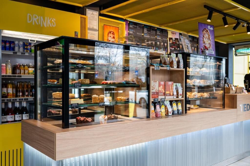 A bakery display with various baked goods and a drinks section.
