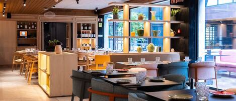 A modern restaurant with wooden ceiling beams, a bar area with shelves of bottles, and a seating area with tables and chairs.