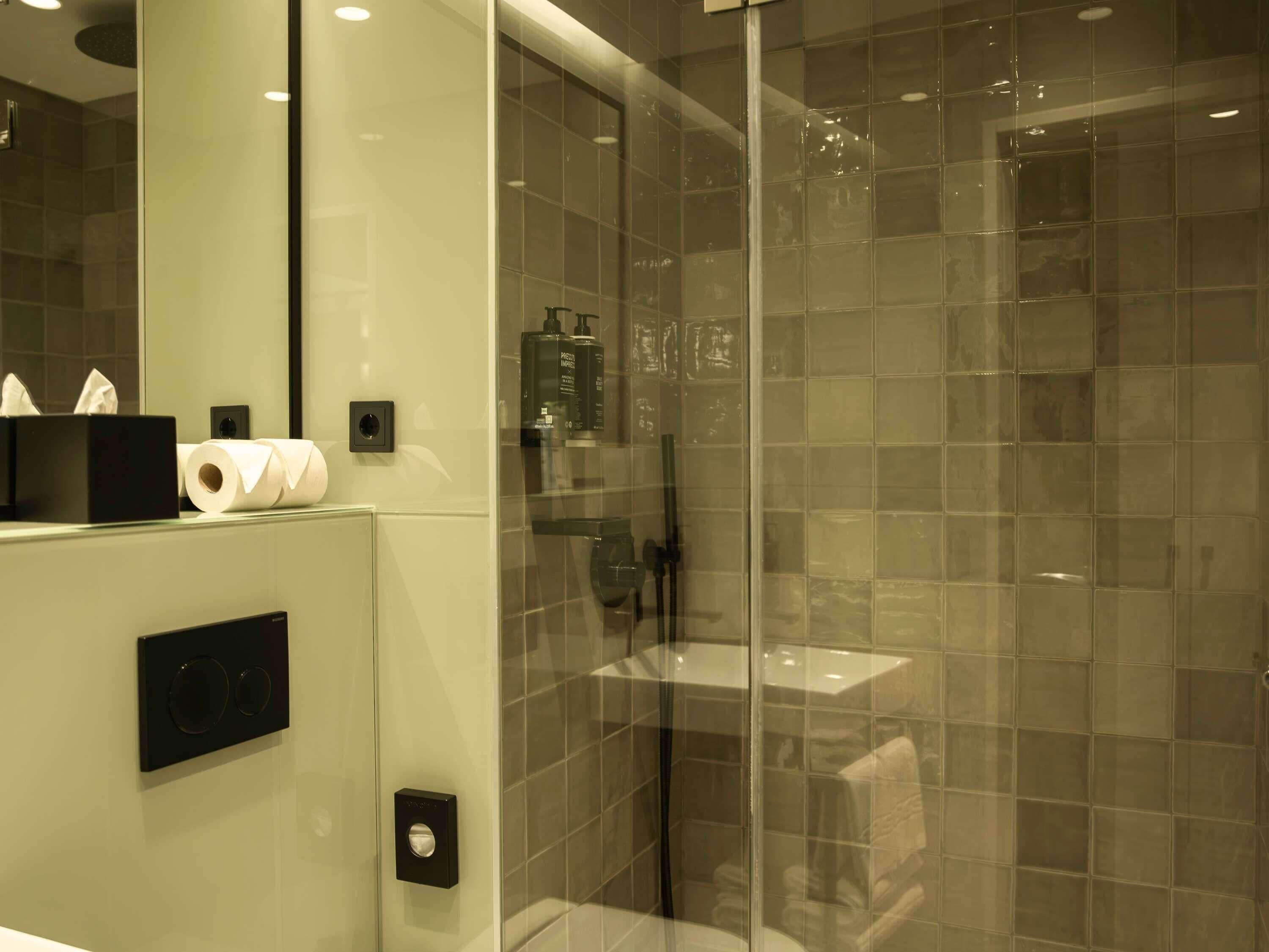 Un baño moderno con cabina de ducha de vidrio, inodoro y lavamanos.
