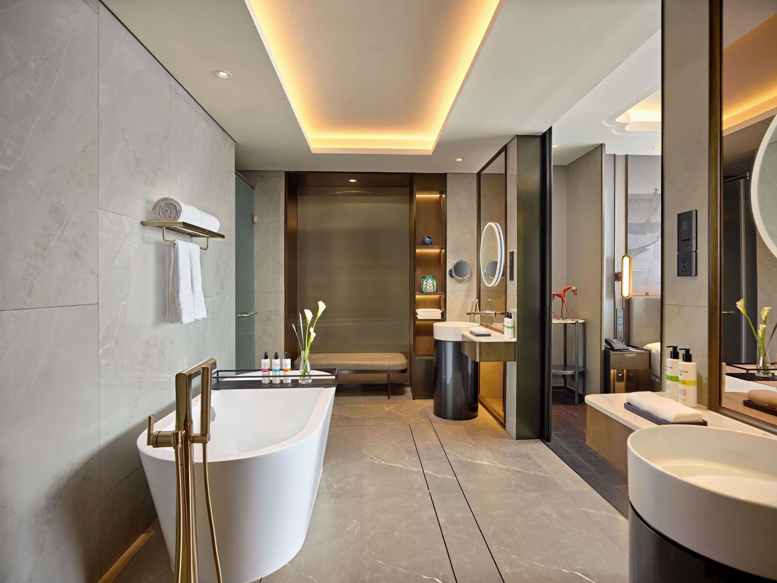 A modern bathroom with a freestanding bathtub, a vanity with a mirror, and a shower area.