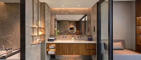 Un baño moderno con lavamanos doble, muebles de madera y cabina de ducha de vidrio.