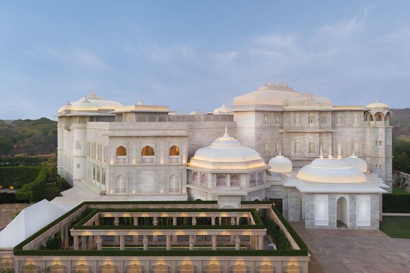 A large, white, multi-tiered building with domed structures and a central courtyard.