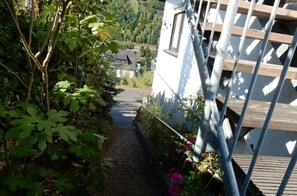 Un étroit sentier menant à un bâtiment entouré d’une clôture en métal.