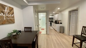 A modern kitchen with white cabinets, a microwave, and a sink.