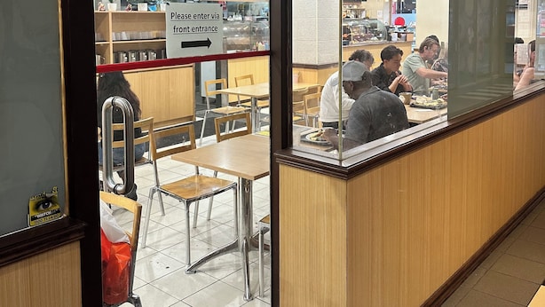 Un interior de restaurante con mostrador, mesas y sillas.