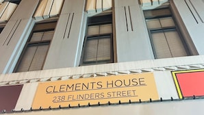 Un edificio alto con un letrero que dice "Clements House 238 Flinders Street".