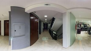 A modern hotel corridor with a staircase, a kitchenette area, and a security door. - HOLLYSTER HOTEL (Curitiba)