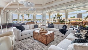 A spacious living room with a large window overlooking a scenic view, a cozy seating area with a coffee table, and elegant drapery. - Your Private Paradise Awaits – Experience Luxury at villa paradise (Cape Coral)