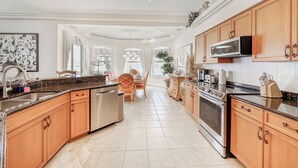 A spacious kitchen with granite countertops, stainless steel appliances, and wooden cabinets. - Your Private Paradise Awaits – Experience Luxury at villa paradise (Cape Coral)