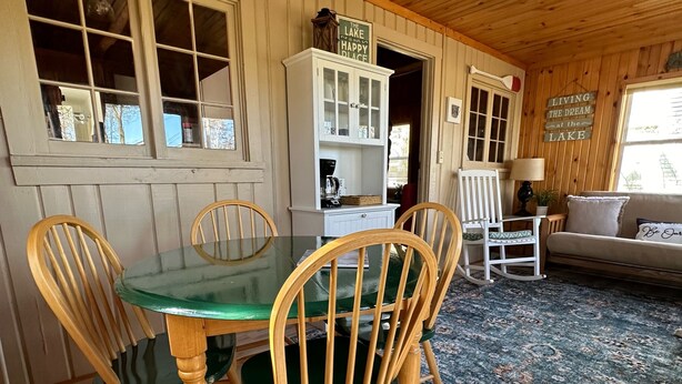 L’intérieur d’un chalet en bois comprend une table à manger, des chaises, un buffet et un canapé.