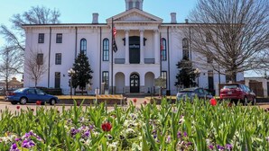 A historic building with a clock tower, a central entrance with columns, and a flagpole. - The Vault - Perfect Location! (Oxford)