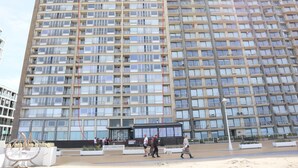 Un immeuble de grande hauteur doté de nombreux balcons et d’une entrée au niveau du sol.