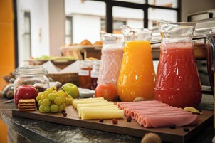 Un bufé de desayuno con diversas opciones de comida y bebidas.