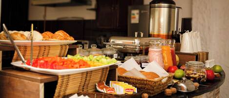 A buffet setup with various food items and condiments.