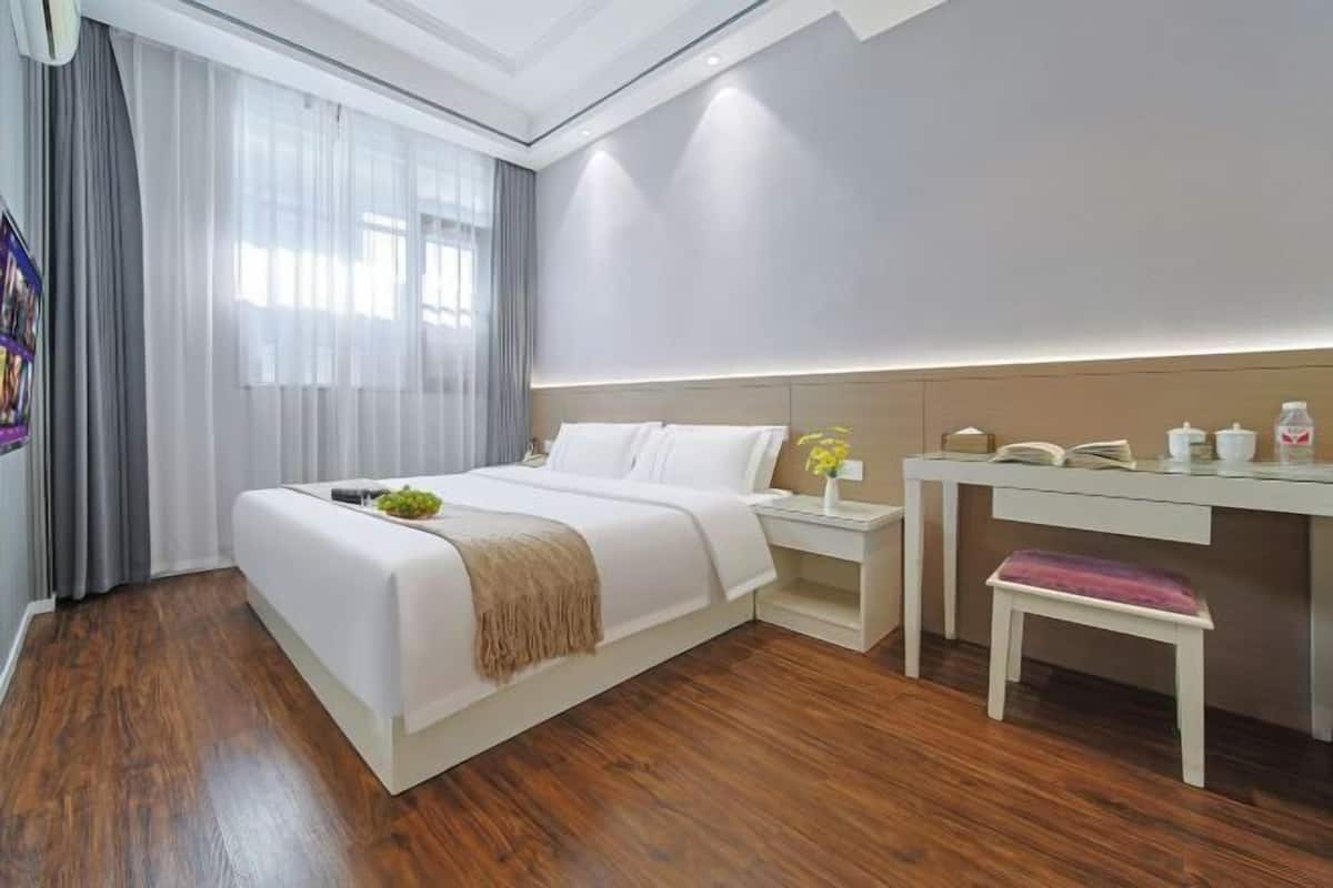 Une chambre d’hôtel moderne, dotée d’un grand lit, d’un bureau et d’une chaise.