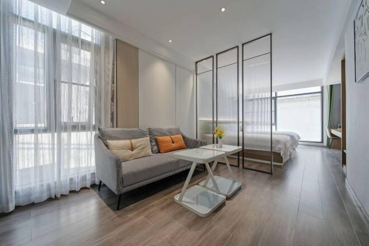Une chambre d’hôtel moderne avec un canapé, une petite table et un lit.