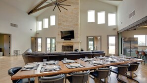 A spacious living area with a large wooden dining table set for six, a built-in fireplace, and a television mounted on the wall. - Game Room, Fireplaces, On-Site Lake! Kaufman Home (Kaufman)
