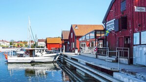 A waterfront scene with a red building labeled "Pizzeria Jakten" and a dock with a boat. - 4 Person Holiday Home in Graso (Gräsö)