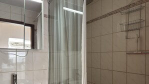 A bathroom with a white sink, a mirror, and a shower curtain. - Kurzurlaub in Bockswiese, Hahnenklee (Goslar)