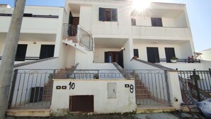 A multi-story residential building with a central staircase, balconies, and a gated entrance. - Casa Marilda 2 - A 200 M dal Mare a Santa Maria Di Leuca (Castrignano del Capo)