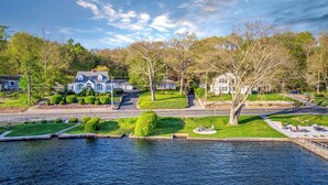 A residential area with a large house, a dock, and a calm water body. - Stunning Lakeside Retreat (Columbia)