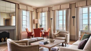 A spacious living room with a fireplace, large windows, and comfortable seating.