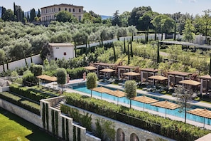 Una piscina al aire libre de temporada, sombrillas