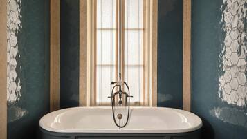 Un bagno con una vasca freestanding, una finestra con vetro satinato e pareti con motivo esagonale.