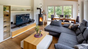 Una sala de estar moderna con televisor, sofá y chimenea.
