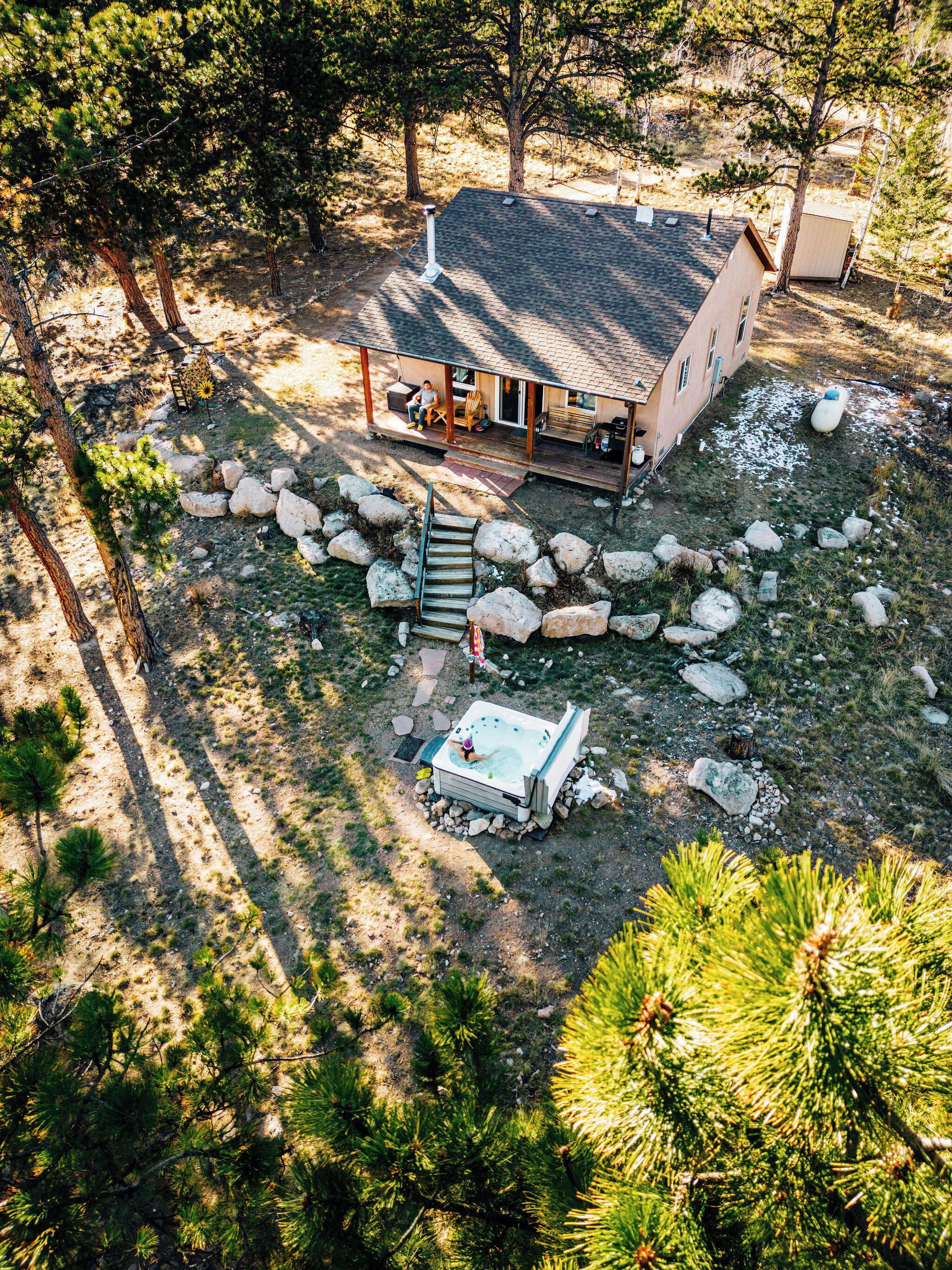 A house with a porch, a hot tub, and a stone pathway.