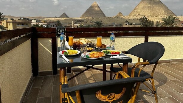 A dining table with breakfast items and a view of the pyramids. - Pyramids Era View (Giza)