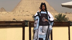 A person standing in front of a pyramid with a clear sky. - Pyramids Era View (Giza)