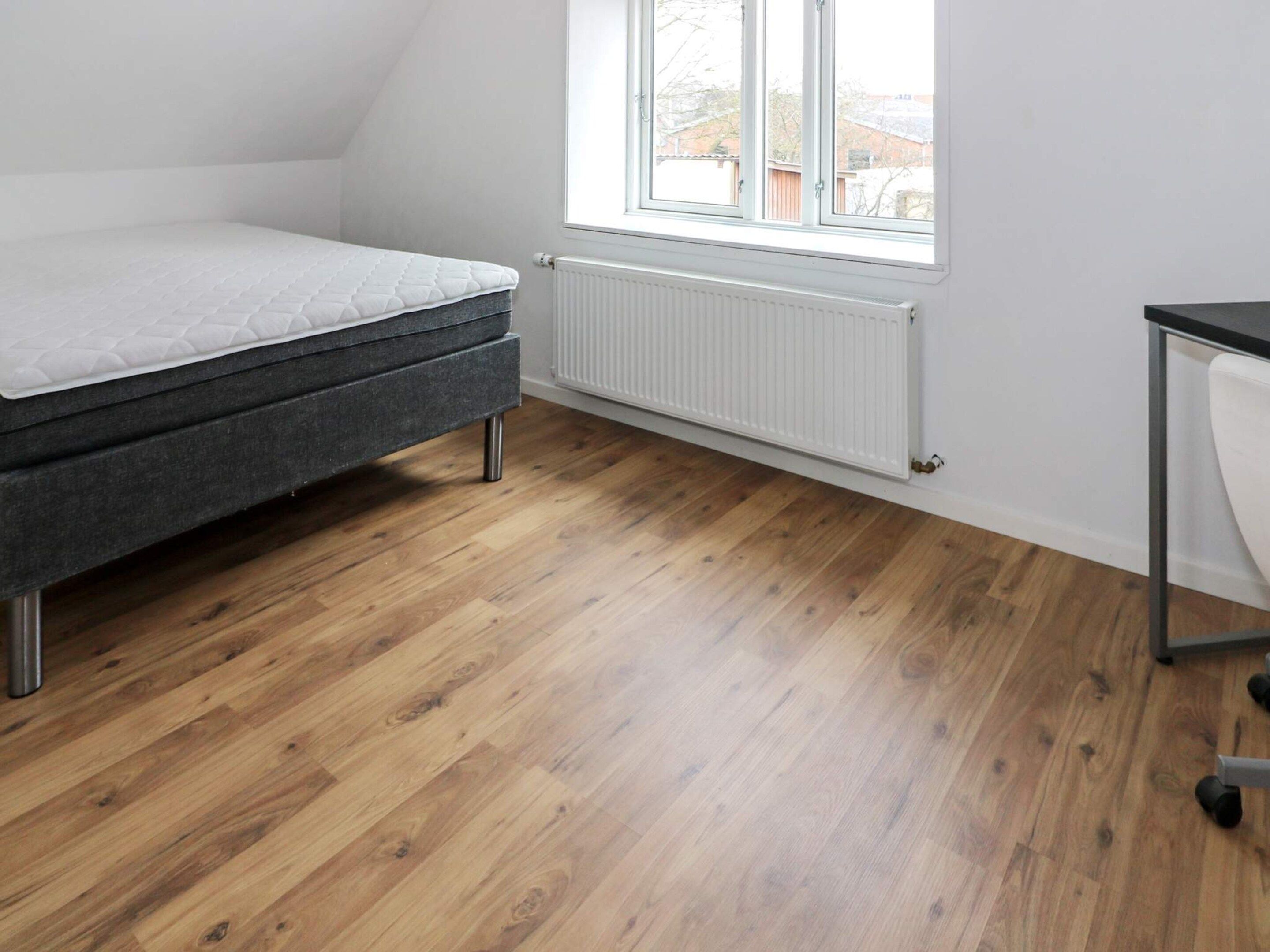 Une chambre à coucher avec un lit, un radiateur et une fenêtre.