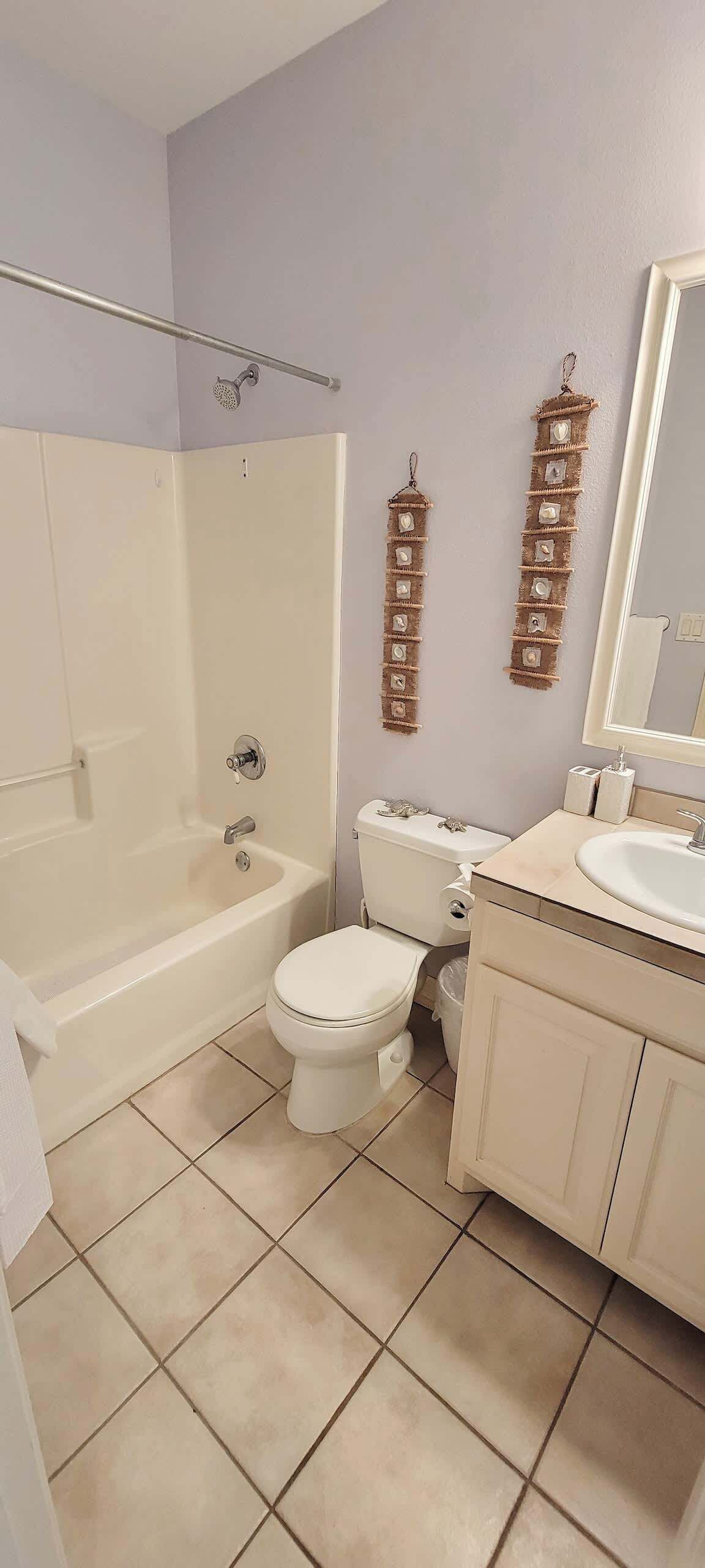 Un baño con bañera, inodoro, lavabo y espejo.