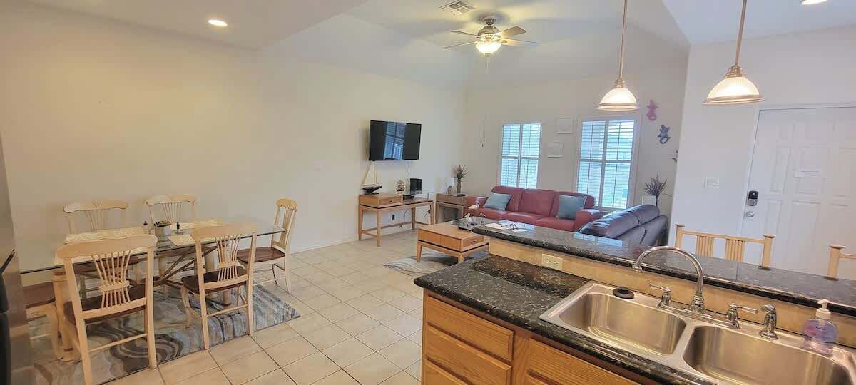 A spacious kitchen with a dining area, a sofa, and a TV.