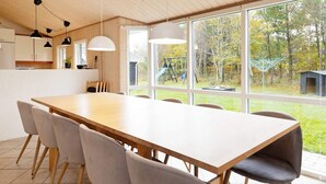 Een moderne keuken met houten kasten en een groot raam met uitzicht op een tuin.