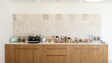A kitchen with a white countertop, wooden cabinets, and a mosaic backsplash.