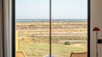 A bedroom with a large sliding glass door leading to an outdoor area with a view of the landscape.