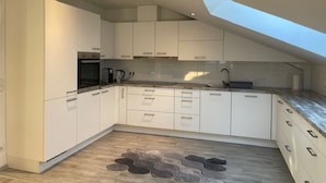 A modern kitchen with white cabinets, a built-in oven, and a skylight. - Baba Apart 1 Große, Moderne Wohnung Direkt an der Schweizer Grenze (Laufenburg)