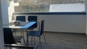 A balcony with a table and chairs, a view of a hilly landscape, and a clear sky. - Baba Apart 1 Große, Moderne Wohnung Direkt an der Schweizer Grenze (Laufenburg)