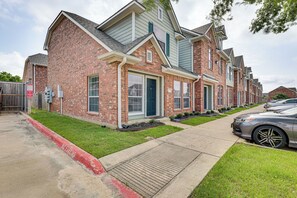 A row of brick townhouses with a central driveway and a parked car. - Central College Station Townhome w/ Community Pool (College Station)